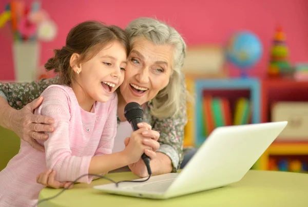 Mulher sênior com neta cantando karaoke — Fotografia de Stock