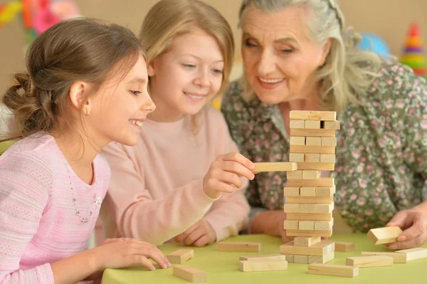 Meisjes en grootmoeder spelen met blokken — Stockfoto