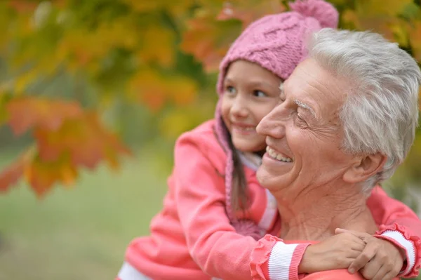 Grandfather and granddaughter in park — Stock Photo, Image