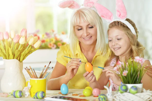 Meisje met moeder schilderij eieren — Stockfoto