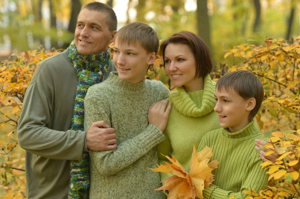 Lächelnde Familie im Herbstwald — Stockfoto