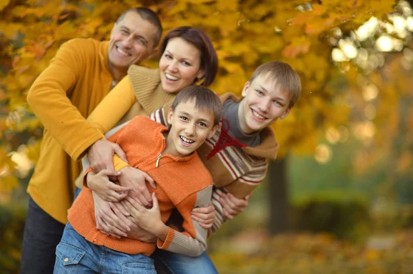 Familia sonriente en bosque de otoño — Foto de Stock
