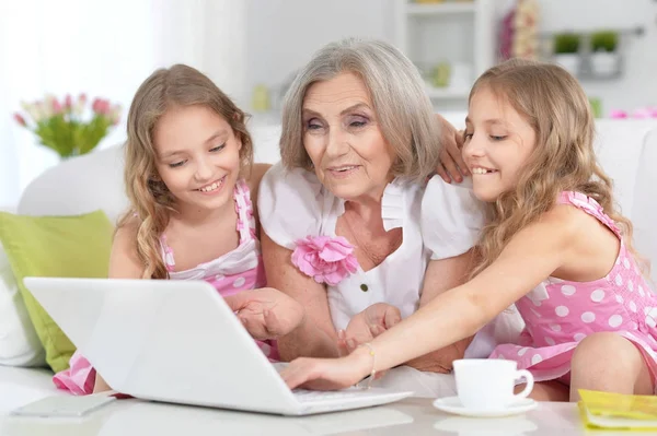 Grand-mère et petites-filles utilisant un ordinateur portable — Photo