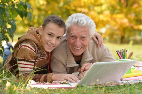 Jongen en grootvader met laptop — Stockfoto