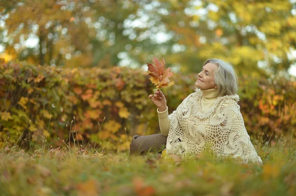 Frau hält Herbstlaub in der Hand — Stockfoto