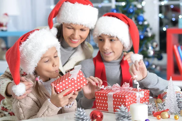 Junge Mutter und Kinder mit Weihnachtsgeschenken — Stockfoto