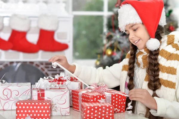 Fille en chapeau de Père Noël avec des cadeaux — Photo