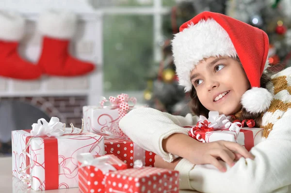 Fille en chapeau de Père Noël avec des cadeaux — Photo