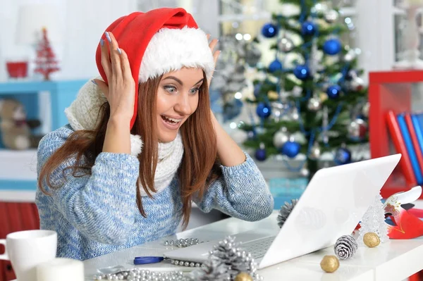 Frau mit Weihnachtsmütze mit Laptop — Stockfoto