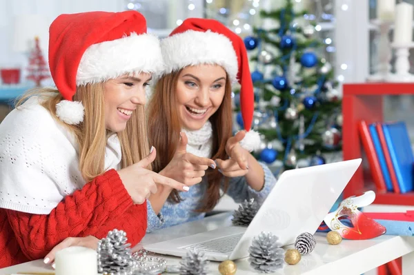 Frauen in Weihnachtsmannhüten mit Laptop — Stockfoto