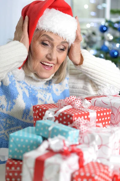 Frau mit Weihnachtsmütze und Geschenken — Stockfoto