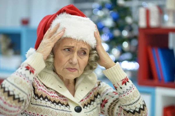 Sad senior woman in Santa hat — Stock Photo, Image