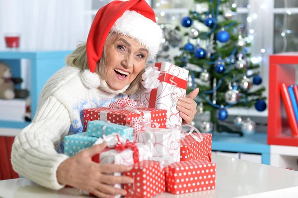 Vrouw in kerstmuts met presenteert — Stockfoto