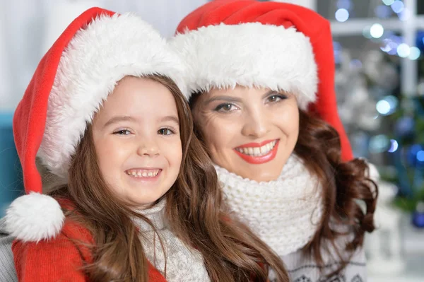 女孩与母亲在圣诞老人帽子 — 图库照片