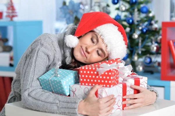 Frau schläft auf Weihnachtsgeschenken — Stockfoto