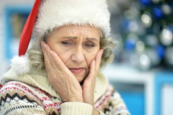 Sad senior woman in Santa hat — Stock Photo, Image