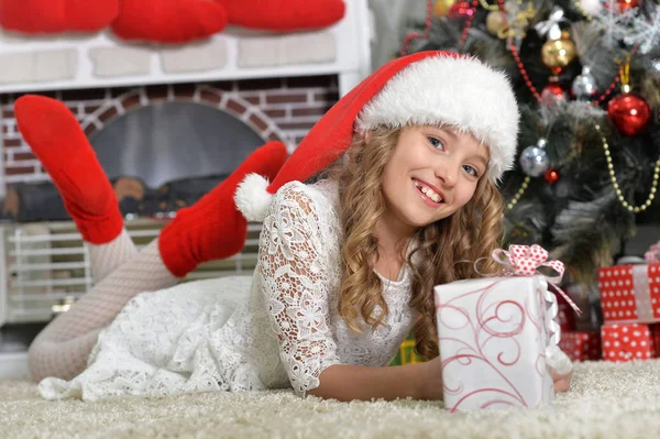 圣诞老人与礼物的帽子的女孩 免版税图库图片