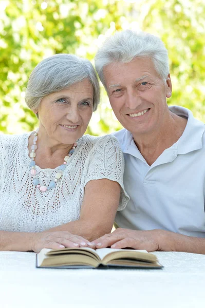 Kitap ile mutlu yaşlı çift — Stok fotoğraf