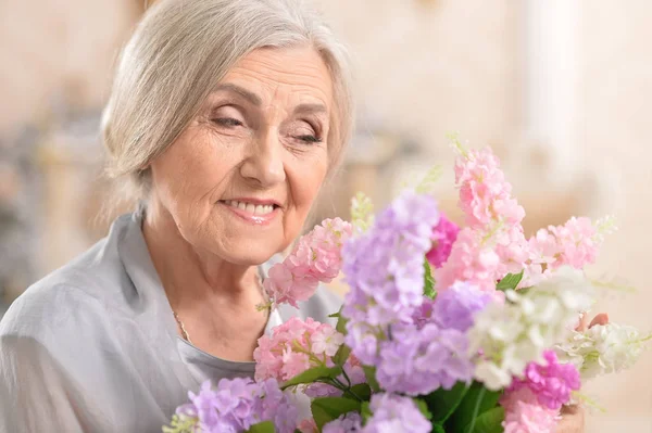 Seniorin mit Strauß weißer Blumen — Stockfoto