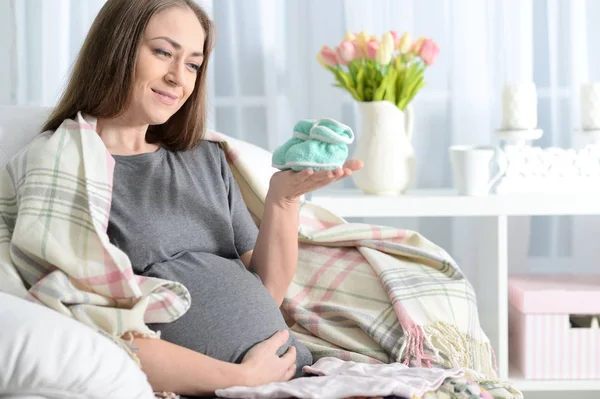 Hermosa Mujer Embarazada Sentada Sillón Con Ropa Bebé —  Fotos de Stock