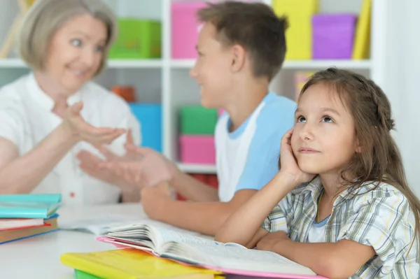 Mamie avec petits-enfants faisant des devoirs — Photo