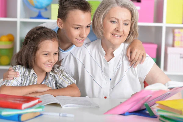 Mormor med barnbarn gör läxor — Stockfoto
