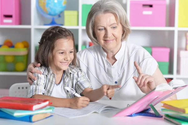 Granny with granddaughter doing homework — Stock Photo, Image