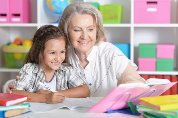 Granny with granddaughter doing homework — Stock fotografie