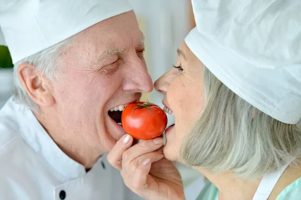 Uśmiechający Się Para Starszy Kucharzy Pomidorów Kuchni — Zdjęcie stockowe