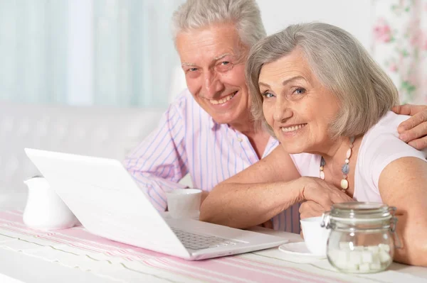 快乐美丽的高级夫妇在家里使用笔记本电脑的肖像 — 图库照片
