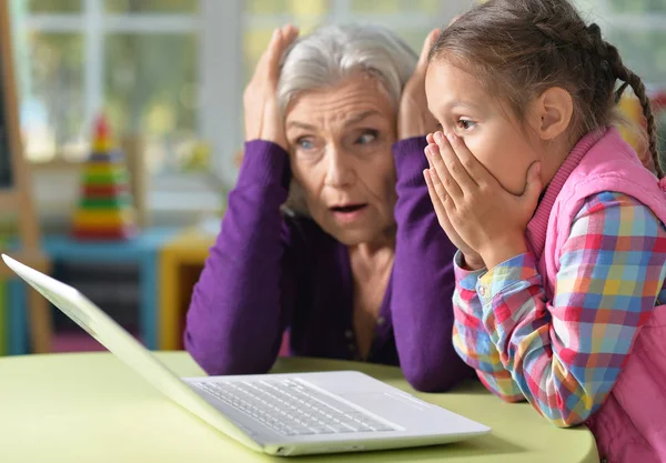 惊讶的肖像的祖母和女儿使用笔记本电脑 — 图库照片