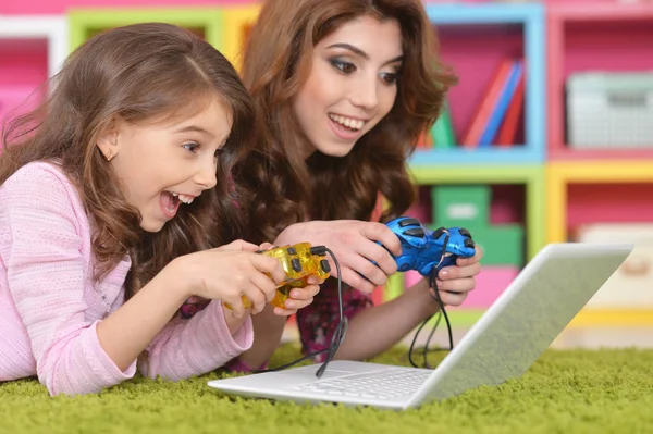 幸福的母亲和女儿玩游戏的笔记本电脑上的肖像 — 图库照片