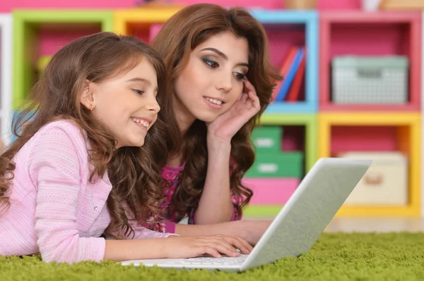 Vrouw en meisje met laptop — Stockfoto