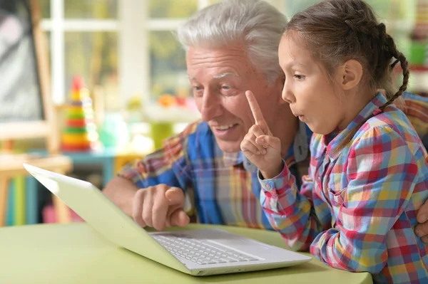 Grootvader en kleindochter met laptop — Stockfoto