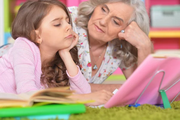 Flicka och mormor göra läxor — Stockfoto