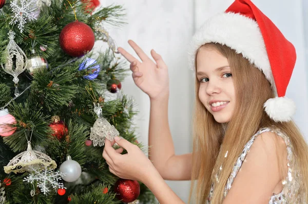 Niedliches Kleines Mädchen Mit Weihnachtsmütze Schmücken Weihnachtsbaum — Stockfoto