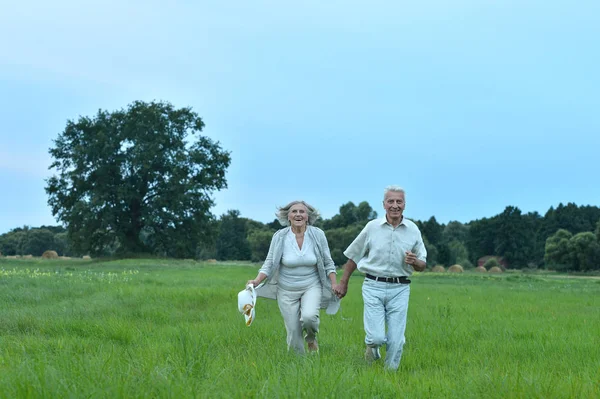 Senior couple running in field — Stock Photo, Image