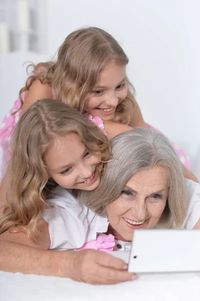 Бабуся з онуками за допомогою смартфона — стокове фото