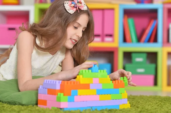 卷发的小女孩玩彩色塑料积木 — 图库照片
