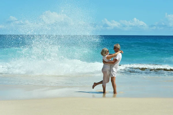 Elderly couple running  on beach — Stock Photo, Image