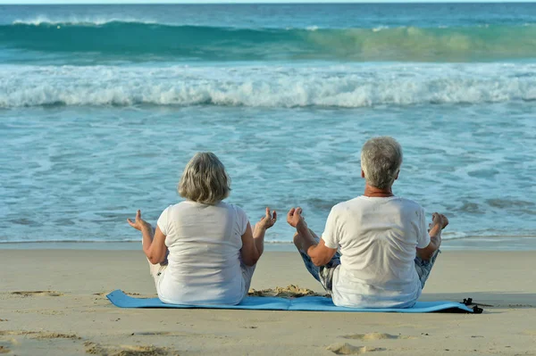 Coppia anziana che corre sulla spiaggia — Foto Stock