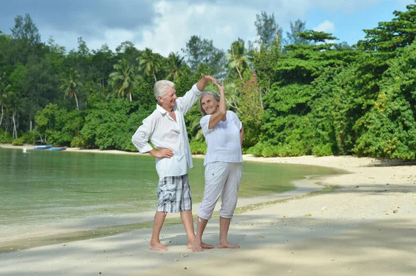 Pareja mayor corriendo en la playa — Foto de Stock