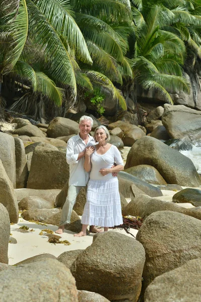 Bejaarde echtpaar rusten op tropisch strand — Stockfoto