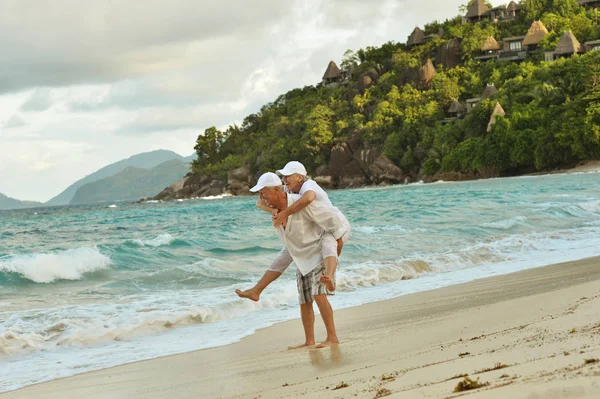 Bejaarde echtpaar uitgevoerd op strand — Stockfoto