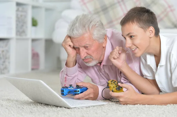 Großvater Und Enkel Liegen Auf Dem Boden Und Spielen Computerspiele — Stockfoto