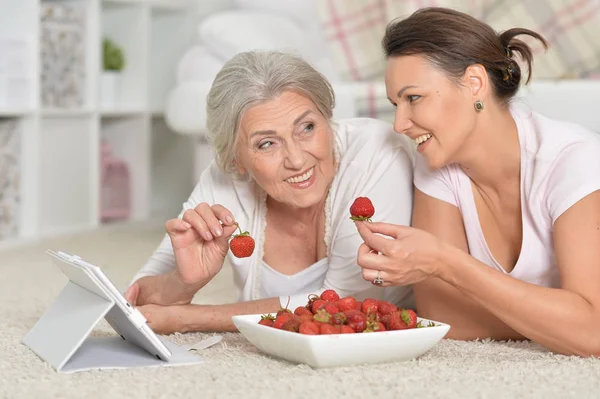 Mother Her Adult Daughter Looking Tablet While Eating Fresh Strawberries — Stock Photo, Image