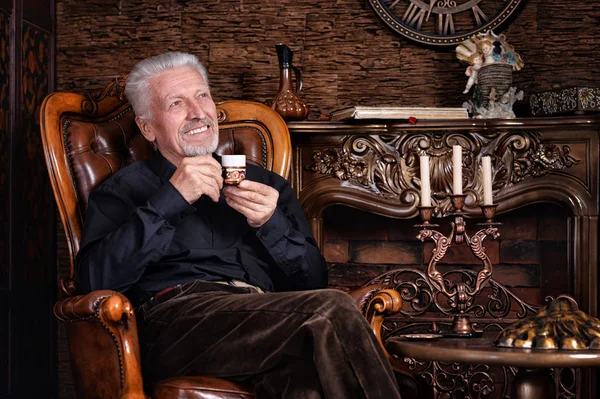 家でコーヒーを飲む年配の男性の笑顔 — ストック写真