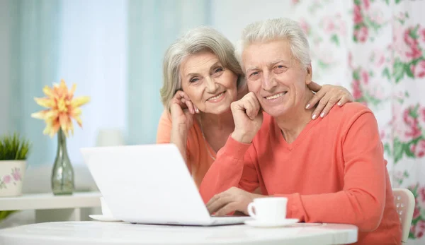 Счастливая пожилая пара с ноутбуком — стоковое фото