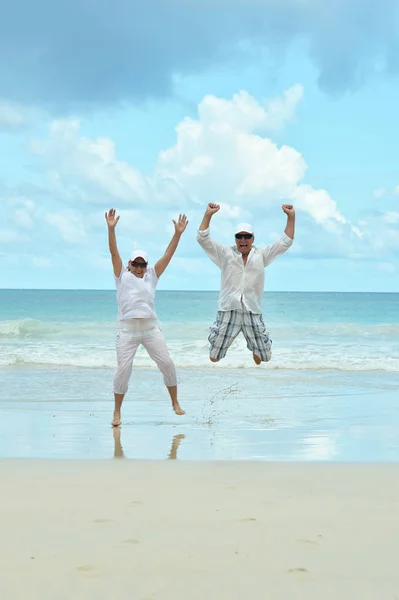 Bejaarde echtpaar uitgevoerd op strand — Stockfoto