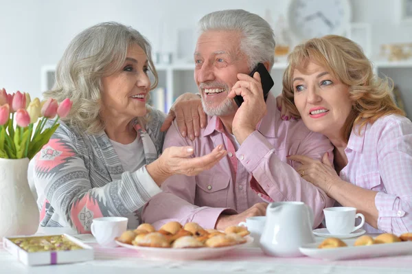 快乐的老年人与智能手机在厨房喝茶 — 图库照片